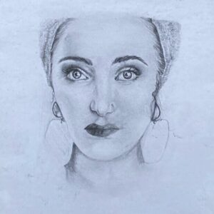 A framed pencil portrait of a woman shown from the shoulders up. She faces forward with a calm, steady gaze. Her features are softly shaded in graphite, and she wears large earrings. The drawing is mounted in a simple black frame against a white background.